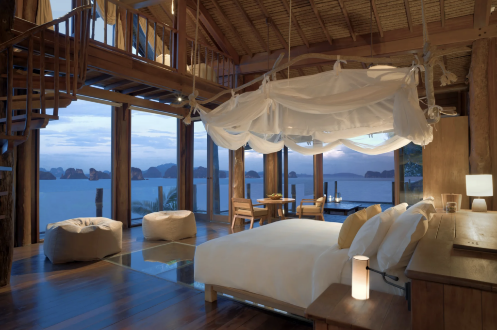 Wooden villa bedroom at Six Senses Yao Noi overlooking Phang Nga Bay in Thailand.
