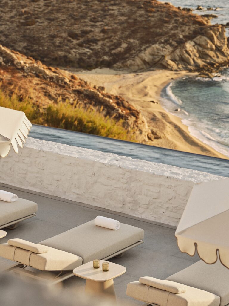 Luxury sun loungers beside an infinity pool overlooking Kalo Livadi Bay at Four Seasons Hotel Mykonos