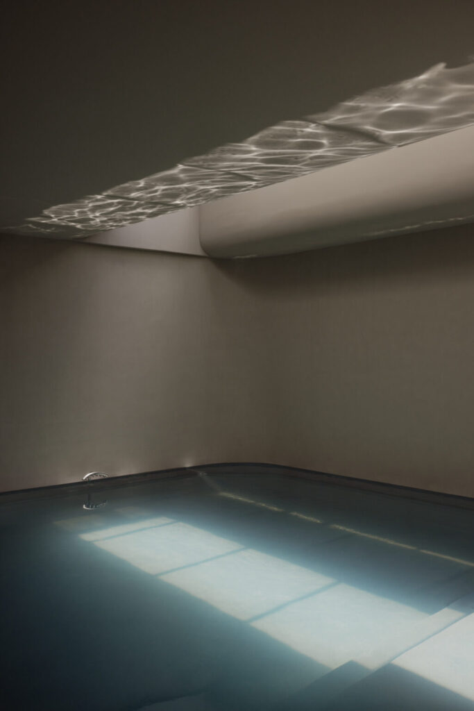Indoor spa pool at JW Marriott Crete Resort & Spa by Block722, where light reflected from the still water ripples across the ceiling of a dim, softly plastered room.