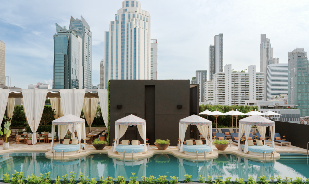 Curtained cabanas on circular platforms in the rooftop pool at Canopy Bangkok Sukhumvit.
