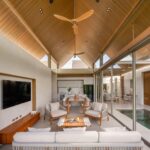 ANSAYA Phuket villa interior in Phuket, Thailand, featuring a high timber pitched ceiling, open-plan living and dining space, and private courtyard pool.