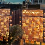 Canopy by Hilton Bangkok Sukhumvit exterior at dusk, featuring an illuminated geometric façade against the Bangkok skyline.