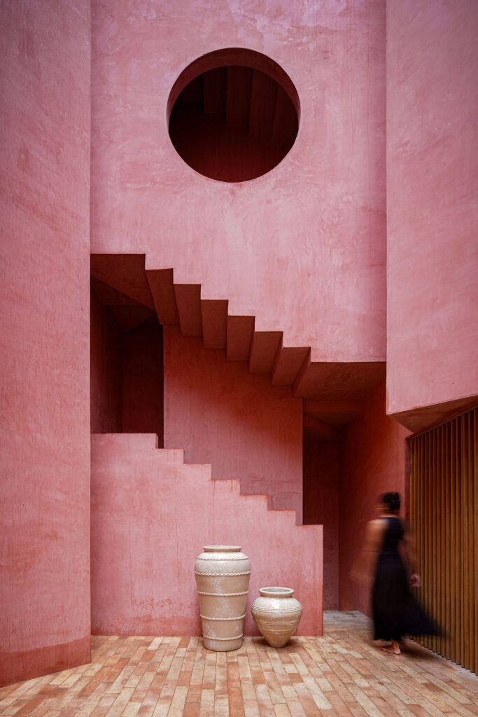 The courtyard staircase of Laiva Plaza hotel by RA! The sculptural stair in Rosa Mexicano handcrafted stucco rises beneath a circular aperture, an example of the sculptural elements unique to Mexican modernism.