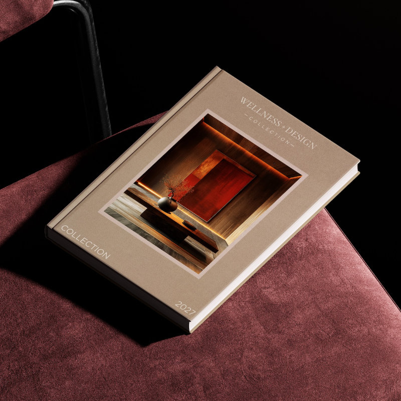 Wellness + Design Collection (WDC) 2027 hardcover book showcasing contemporary hospitality architecture and interior design, displayed on a burgundy chair.